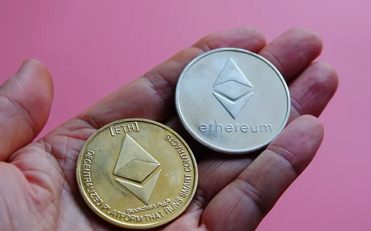 hand holding metal coins with ethereum logo on it
